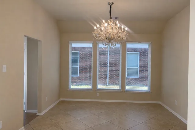 a view of a livingroom with a chandelier fan and windows