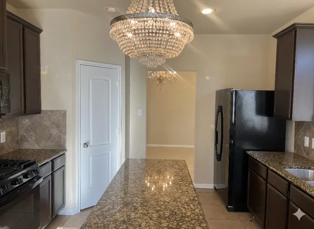 a kitchen with stainless steel appliances granite countertop a stove a sink and a refrigerator