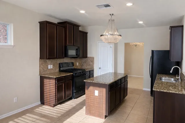 a kitchen with a sink a microwave a stove and refrigerator