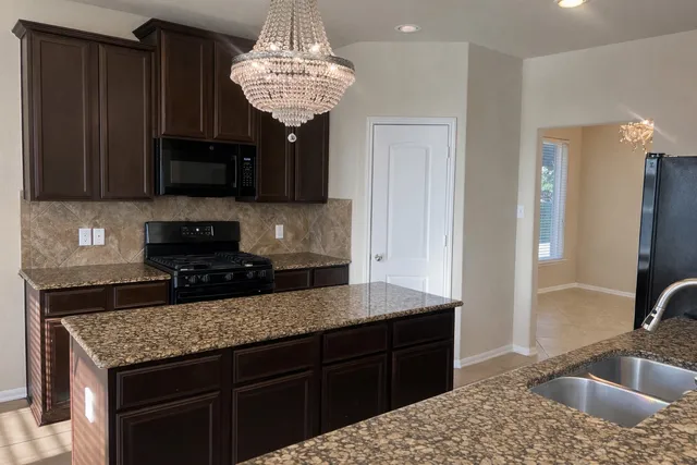 a kitchen with stainless steel appliances granite countertop a stove cabinets and a refrigerator
