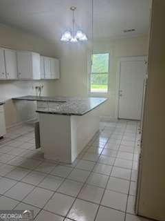 1803 Rocky Creek Road Macon, GA 31206 - Photo 9 of 10 a kitchen with granite countertop white cabinets and window