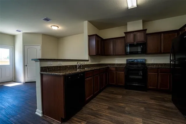 a kitchen with stainless steel appliances granite countertop a stove a sink and a refrigerator