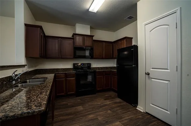 a kitchen with a refrigerator stove and cabinets