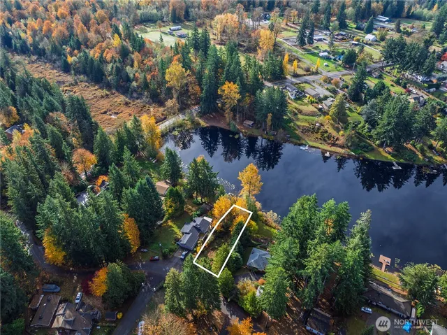 an aerial view of a house with a yard and lake view