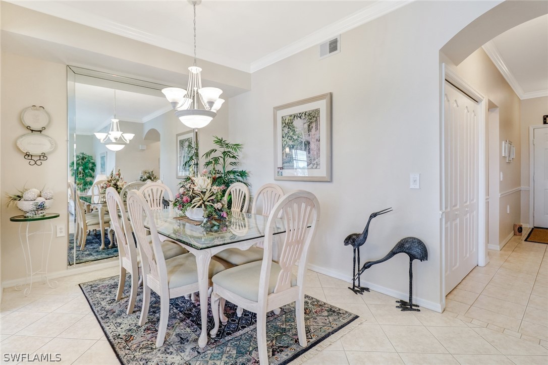 14101 Brant Point Circle, Unit 3303 Fort Myers, FL 33919 - Photo 2 of 30 a dining room with furniture and a chandelier