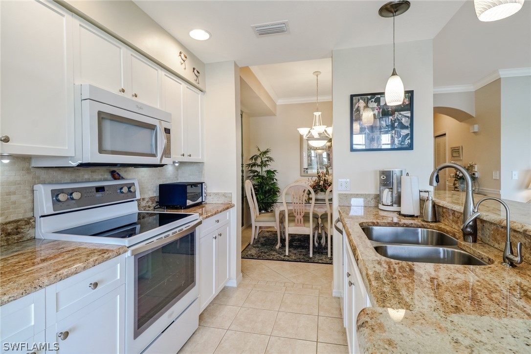 14101 Brant Point Circle, Unit 3303 Fort Myers, FL 33919 - Photo 4 of 30 a kitchen with granite countertop a sink stainless steel appliances and cabinets