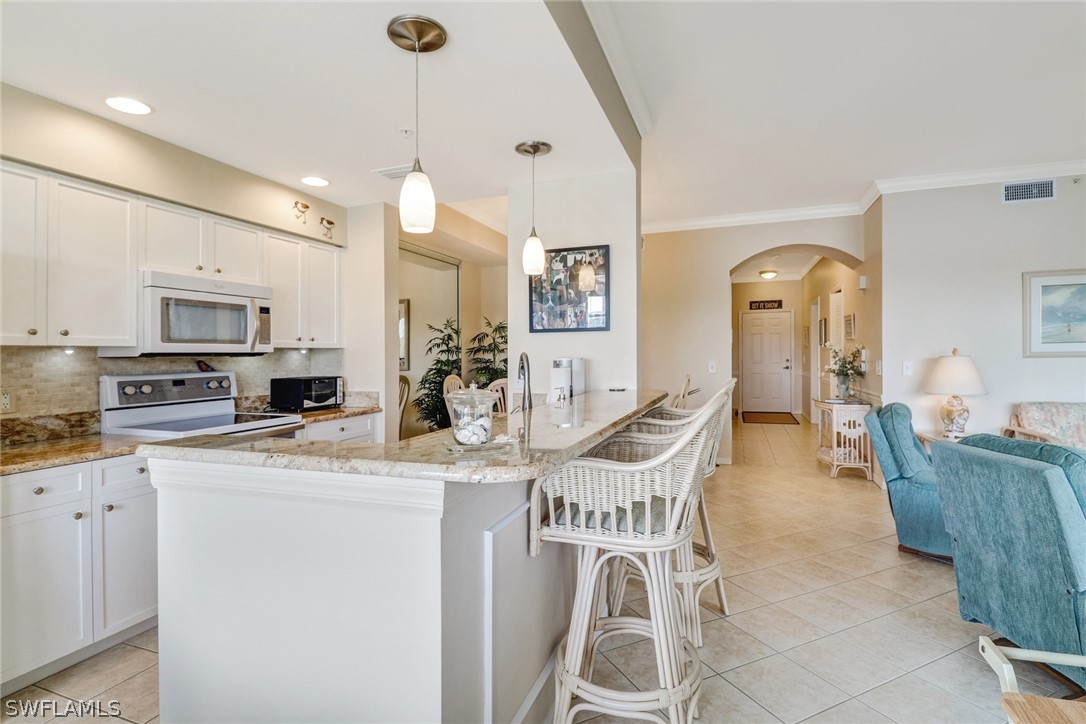 14101 Brant Point Circle, Unit 3303 Fort Myers, FL 33919 - Photo 5 of 30 a dining room with stainless steel appliances kitchen island granite countertop a dining table chairs and a refrigerator