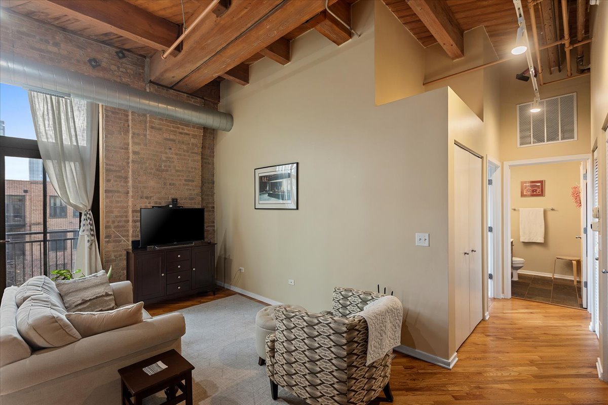 1040 West Adams Street, Unit 459 Chicago, IL 60607 - Photo 5 of 30 a living room with furniture and a flat screen tv