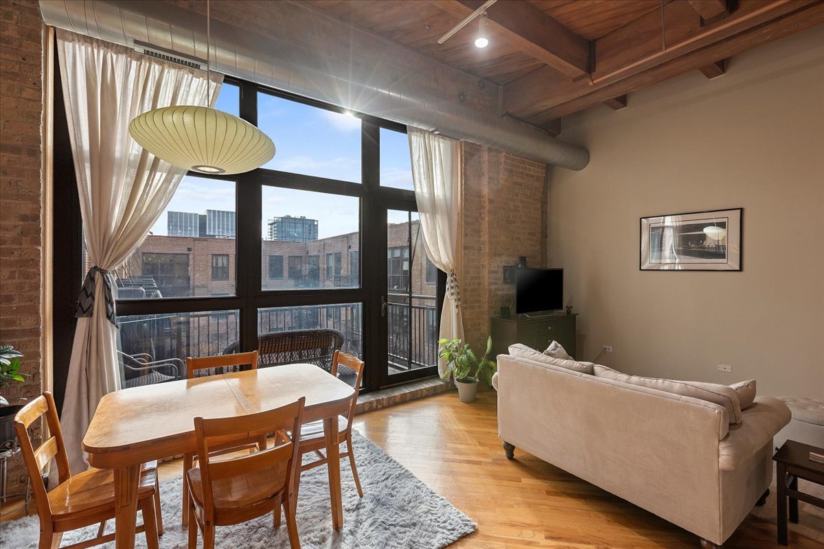 1040 West Adams Street, Unit 459 Chicago, IL 60607 - Photo 6 of 30 a living room with a table and a dining table with wooden floor