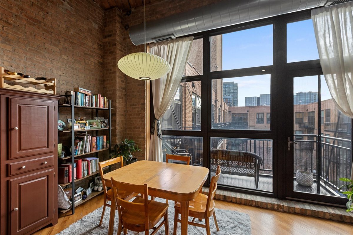 1040 West Adams Street, Unit 459 Chicago, IL 60607 - Photo 7 of 30 a view of a dining room with furniture and a floor to ceiling window