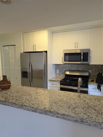 a view of a kitchen with wooden floor and a sink