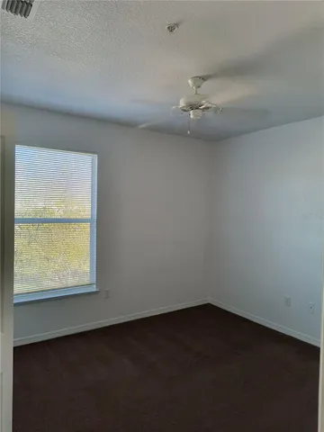 an empty room with a chandelier fan