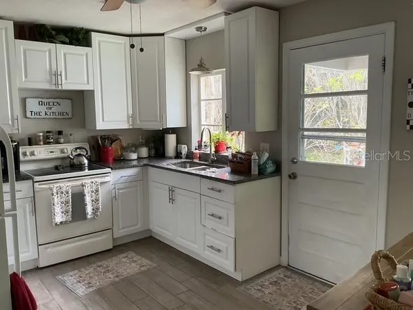 a kitchen with stainless steel appliances white cabinets and a window