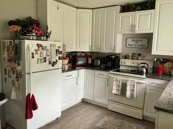 a kitchen with a refrigerator and white cabinets
