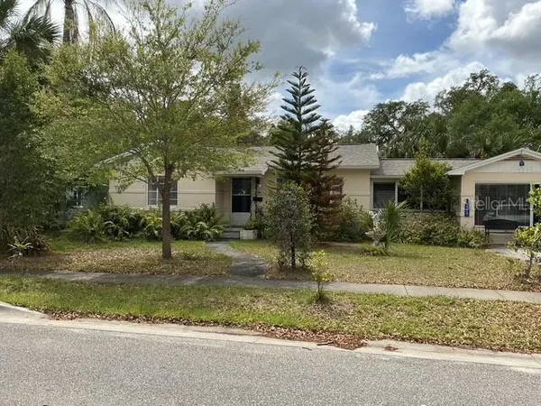 a view of a house with a yard and large tree
