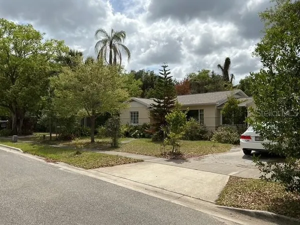 a front view of a house with a yard and a garden