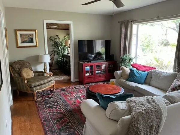 a living room with furniture a flat screen tv and a large window
