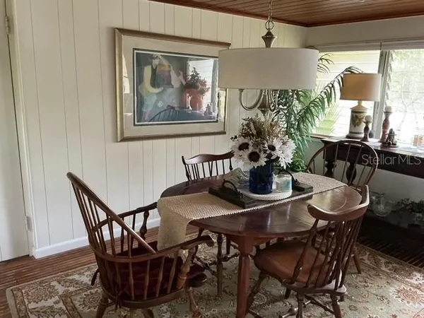 a dining room with furniture potted plants and wooden floor