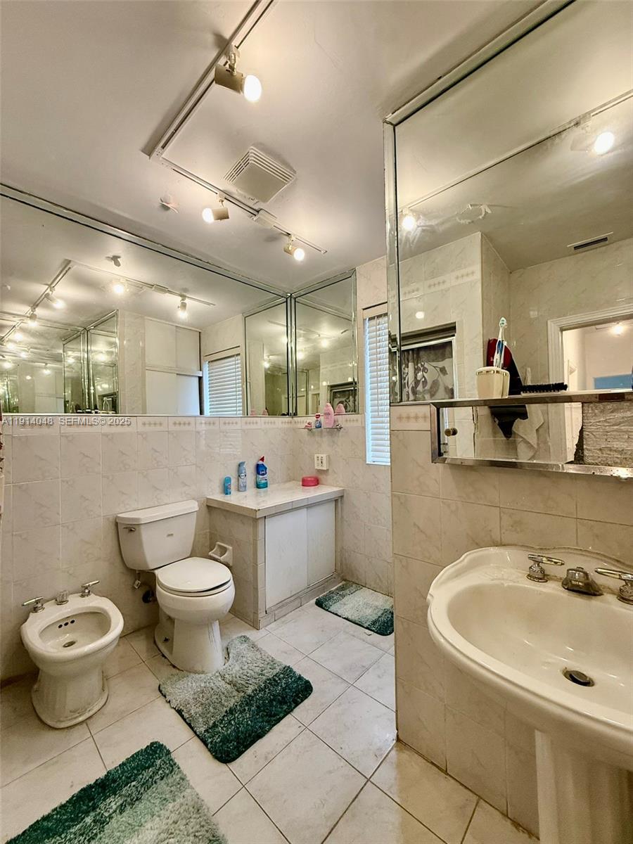 3000 Northwest 5th Street Miami, FL 33125 - Photo 17 of 54 a bathroom with a sink toilet a mirror and bathtub