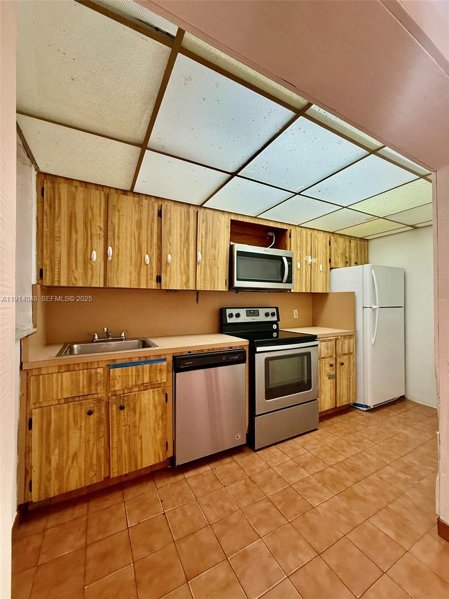 3000 Northwest 5th Street Miami, FL 33125 - Photo 39 of 54 a kitchen with stainless steel appliances granite countertop a stove and a refrigerator