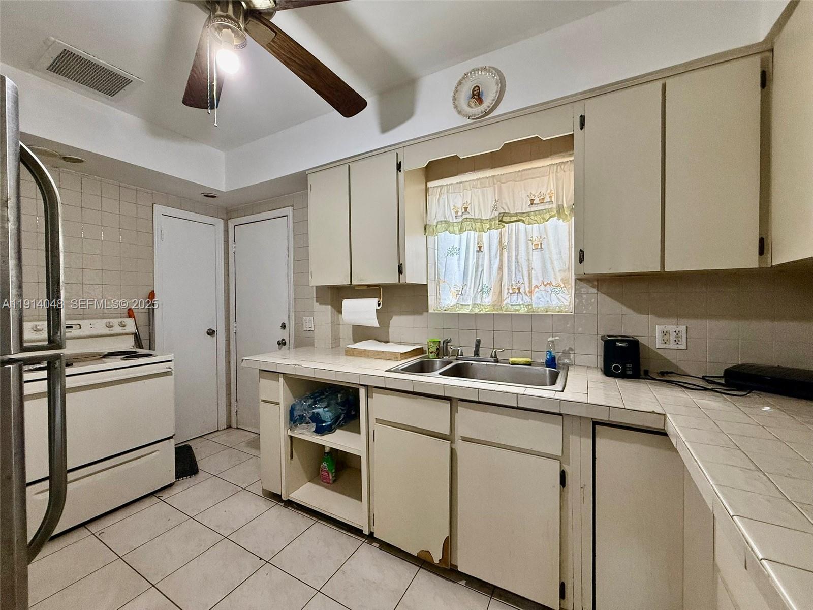 3000 Northwest 5th Street Miami, FL 33125 - Photo 9 of 54 a kitchen with a stove sink and cabinets