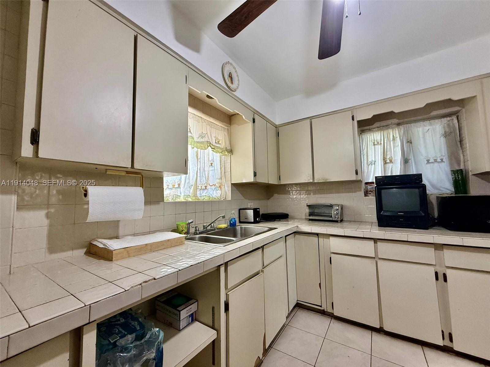 3000 Northwest 5th Street Miami, FL 33125 - Photo 10 of 54 a kitchen with a sink window and cabinets