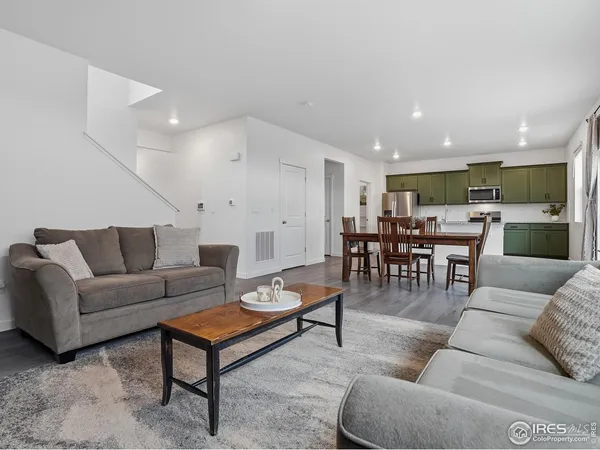 a living room with furniture and view of kitchen