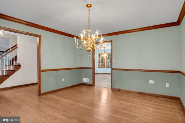 a view of a room with wooden floor and chandelier