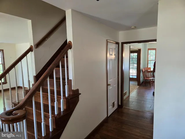 a view of a hallway with wooden floor and stairs