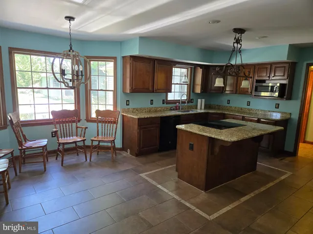 a kitchen with a stove a sink a counter top space and dining table