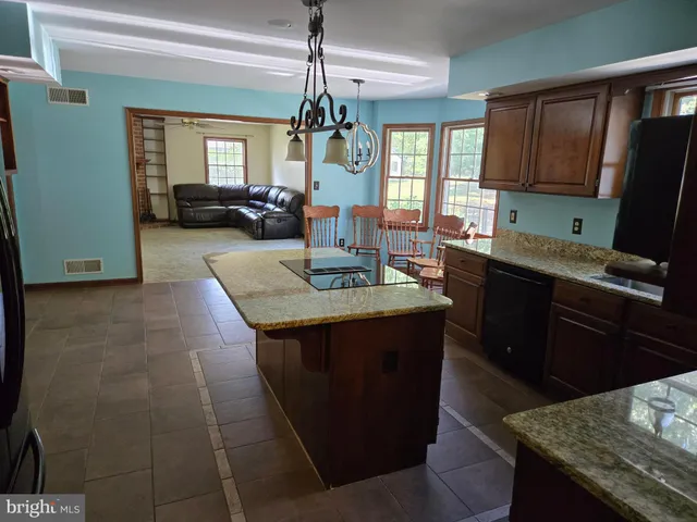 a kitchen with granite countertop sink stove and granite counter top