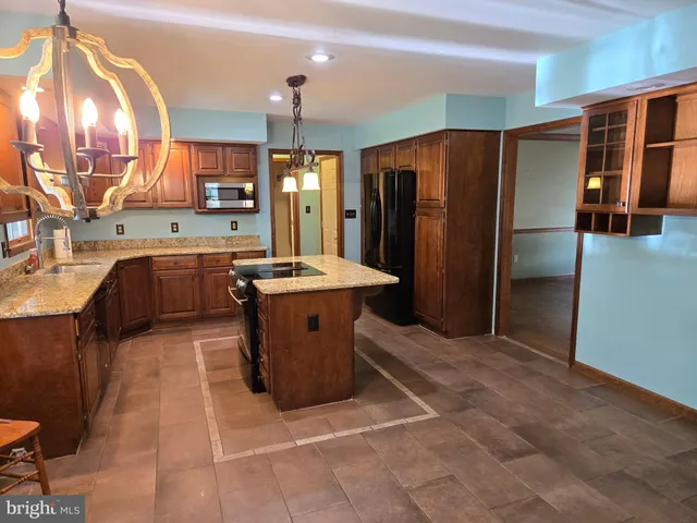 a large kitchen with a large counter top stainless steel appliances and cabinets