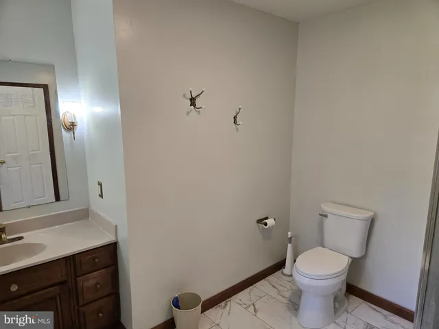 a bathroom with a granite countertop toilet and a sink