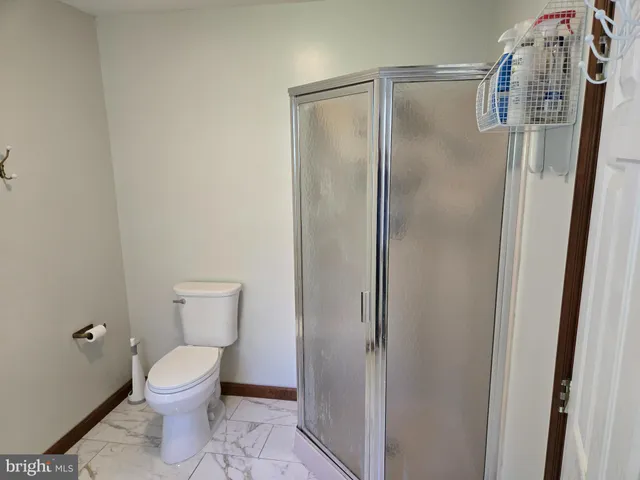 a bathroom with a toilet and a shower