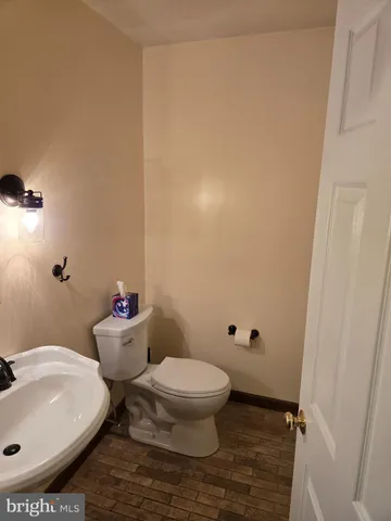 a white toilet sitting next to a white sink and vanity