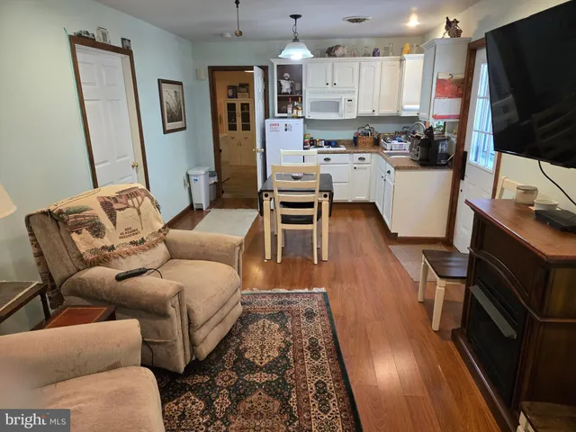 a living room with furniture a flat screen tv and kitchen view