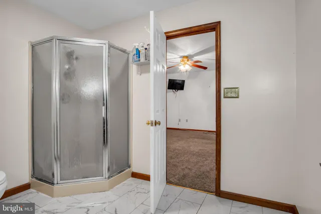 a bathroom with a glass shower door and mirror