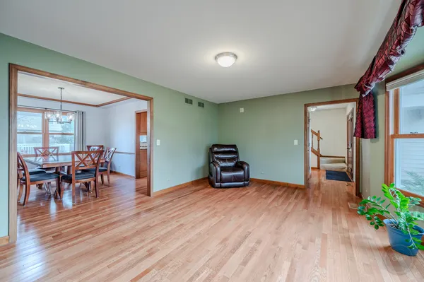a view of hallway with livingroom and wooden floor