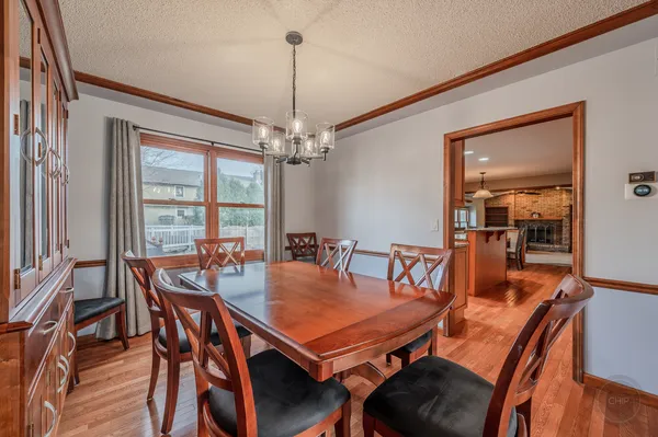 a dining room with furniture a chandelier and wooden floor