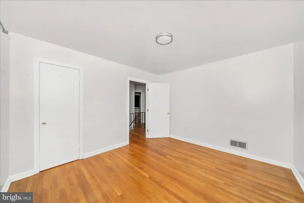 a view of empty room with wooden floor