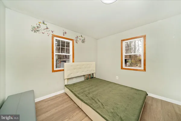 a view of a bedroom with wooden floor and windows