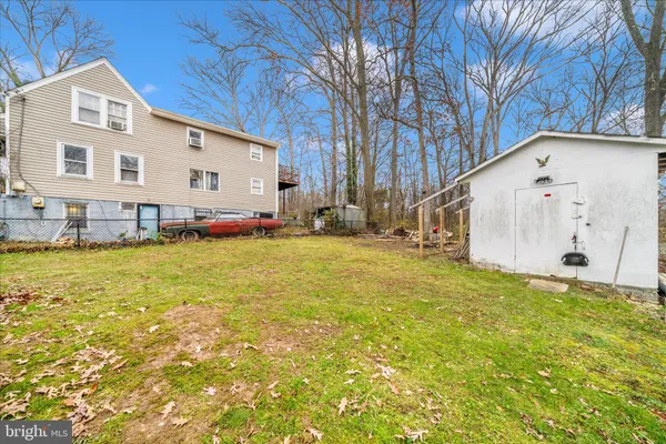 a view of a white house with a big yard and large tree