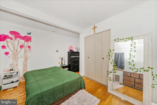 a bedroom with a bed dresser and a window