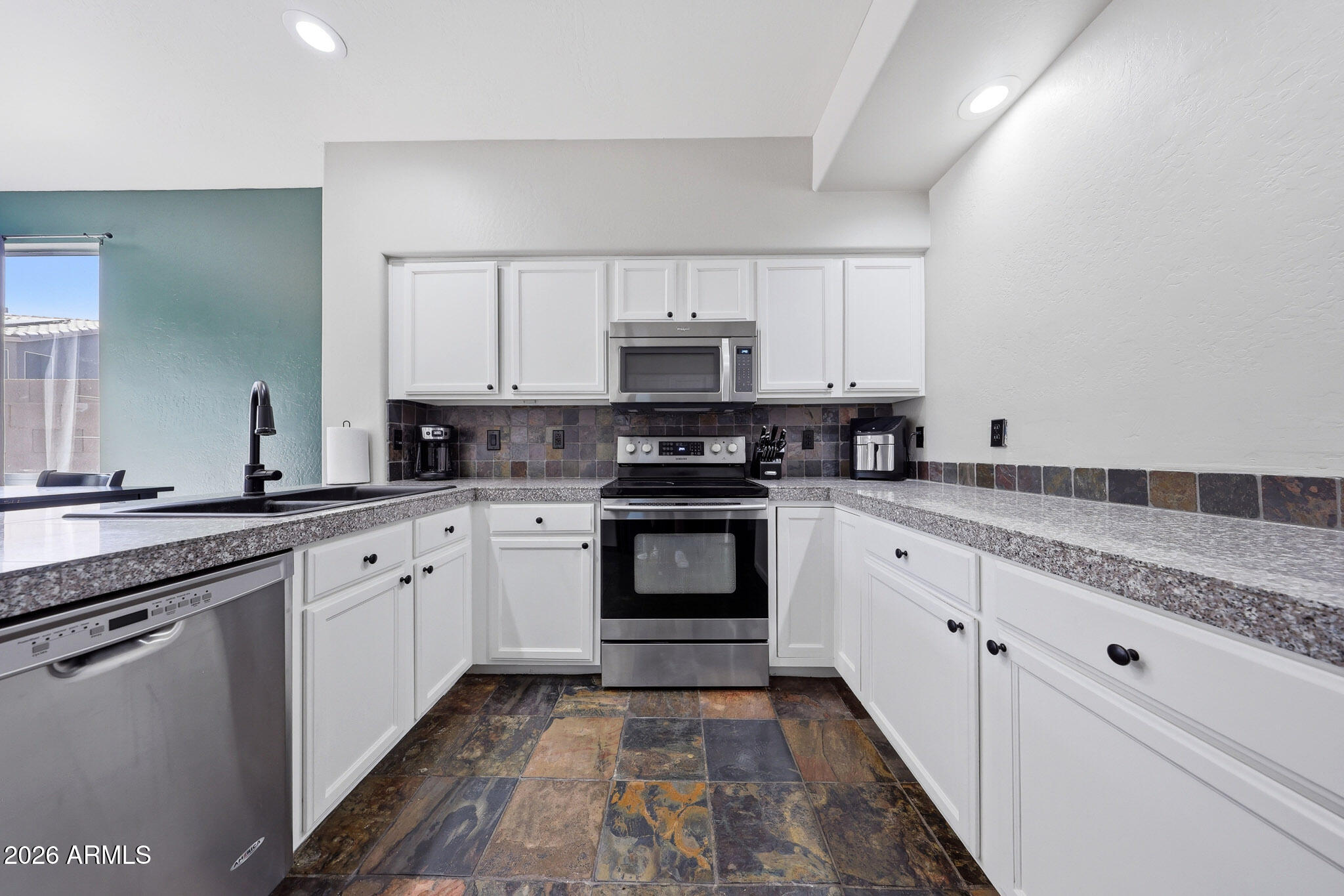 2167 East Nighthawk Way Phoenix, AZ 85048 - Photo 9 of 28 a kitchen with granite countertop a stove top oven sink and cabinets
