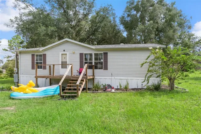 a view of a house with a backyard and a slide