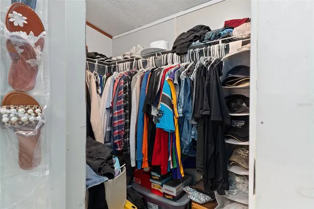 a view of walk in closet with clothes and shoes