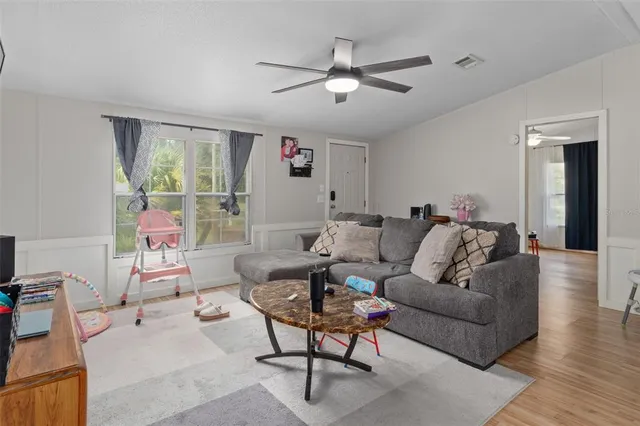 a living room with furniture and a ceiling fan