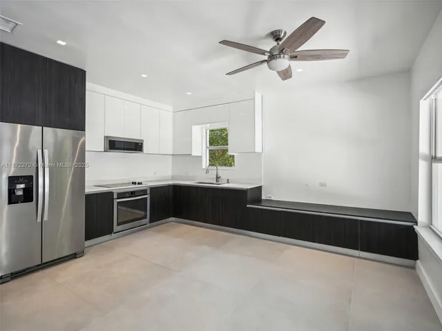 a kitchen with granite countertop a refrigerator and a sink