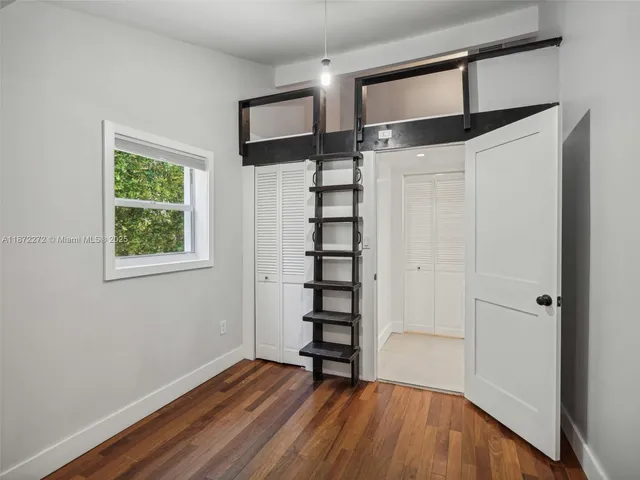 a view of a hallway with wooden floor and entryway
