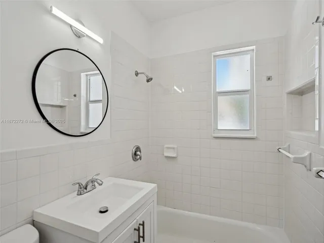 a bathroom with a sink a mirror a vanity and a shower